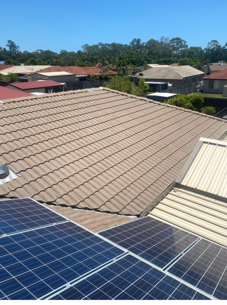 Faded brown tile roof and solar panels prior to starting a complete roof restoration